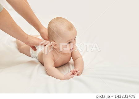 Caucasian Baby Receiving Gentle Massage On Soft White Blanket With Tender Care And Parental Love Caucasian Baby Receiving Gentle Massage On Soft White Blanket With Tender Care And Parental Love 142232479
