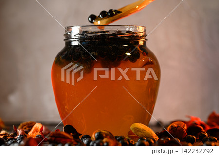 Chokeberries and honey in a glass jar 142232792