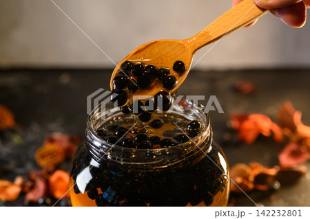 Chokeberries and honey in a glass jar 142232801