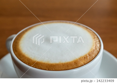 Close up of hot cappuccino white cup smooth creamy milk foam representing fresh coffee cafe culture breakfast refreshment relaxing morning drink Close up of hot cappuccino white cup smooth creamy milk foam representing fresh coffee cafe culture breakfast refreshment relaxing morning drink 142233409