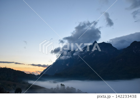 Majestic mountain peaks covered by low clouds morning mist at sunrise dramatic sky creating peaceful natural landscape tranquil wilderness atmosphere Majestic mountain peaks covered by low clouds morning mist at sunrise dramatic sky creating peaceful natural landscape tranquil wilderness atmosphere 142233438
