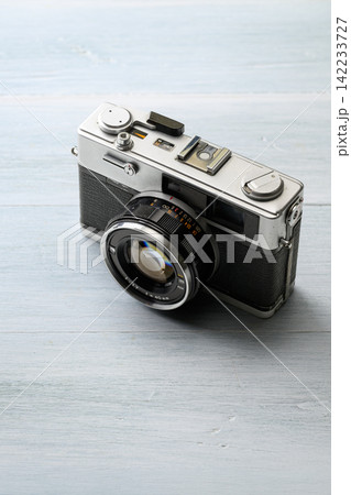 木製テーブルに置かれたヴィンテージフィルムカメラ 木製テーブルに置かれたヴィンテージフィルムカメラ 142233727