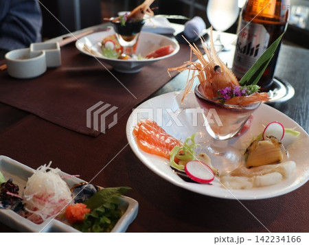 和食店のテーブルに並ぶ刺身の盛り合わせと前菜 和食店のテーブルに並ぶ刺身の盛り合わせと前菜 142234166