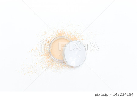 Open compact reveals soft natural toned powder. Slight dusting suggests gentle application. Minimalist white background enhances product clarity. Ideal for beauty, skincare, or makeup editorial use 142234184