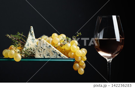 Glass of white wine with grapes, blue cheese and thyme. 142236283