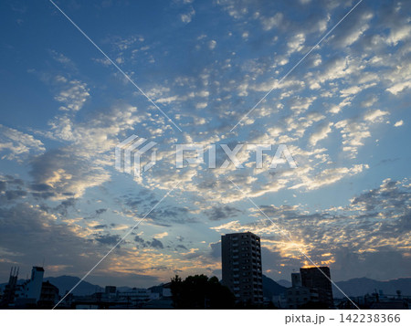 朝焼けの空いっぱいに広がる雲と街並み 朝焼けの空いっぱいに広がる雲と街並み 142238366