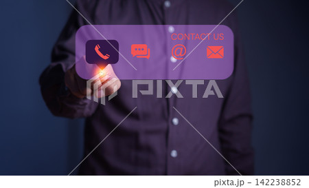 Adult man touching a glowing virtual interface screen featuring contact us icons. Digital communication technology concept for customer support, email, chat, and phone network services. Adult man touching a glowing virtual interface screen featuring contact us icons. Digital communication technology concept for customer support, email, chat, and phone network services. 142238852