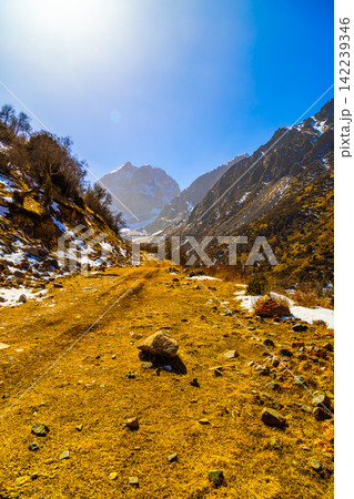 Winding Dirt Road Through Mountain Valley in Kyrgyzstan 142239346