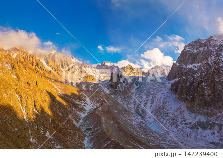 Panoramic View of Rugged Mountain Range with Glacier 142239400