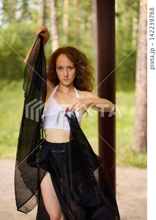 Elegant woman in natural setting with captivating eyes and attire 142239768