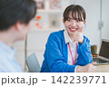 サムズアップで同僚と会話する女性のオフィスシーン 142239771