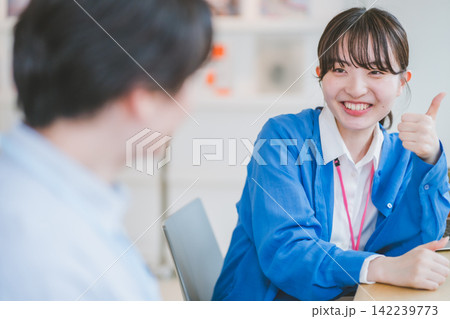 親指を立てながら笑顔で話す女性のビジネスシーン 親指を立てながら笑顔で話す女性のビジネスシーン 142239773
