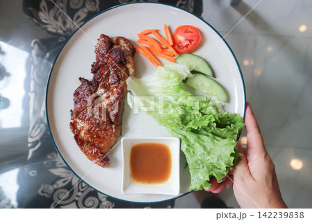 pork steak or grilled pork and salad or pork chop and vegetable pork steak or grilled pork and salad or pork chop and vegetable 142239838