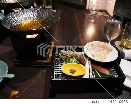 卓上コンロの鍋と焼き物が並ぶ和食の膳 夕食のはじまり 卓上コンロの鍋と焼き物が並ぶ和食の膳 夕食のはじまり 142240488
