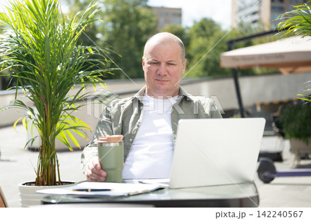 Mature professional planning work at outdoor cafe 142240567