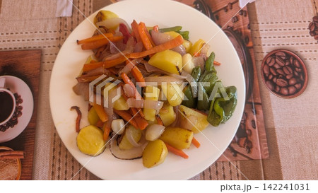 Stir fried potatoes and vegetables on a white plate 142241031