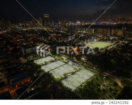 Miami, Florida, USA - June 10, 2025: Sport activity in Flamingo park. Sport activity. Aerial basketball and football field in park. Night Miami beach cityscape. Tennis field aerial view at night 142241192
