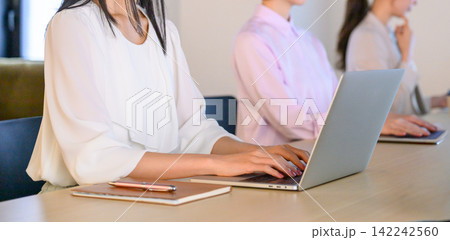 オフィスでノートパソコンを操作する女性社員たちの風景 142242560