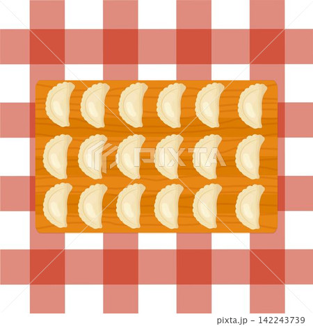 Dumplings on a wooden cutting board on red checkered tablecloth Dumplings on a wooden cutting board on red checkered tablecloth 142243739