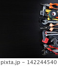 Assorted hand tools arranged along right edge on dark wooden surface, copy space for repair 142244540