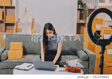 Woman recording live stream preparing packages for online selling Woman recording live stream preparing packages for online selling 142244662