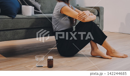 Young Asian woman sitting in bed and holding her head in pain with headache, feeling depressed and suffering 142244685