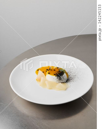 Intimate shot of handcrafted custard adorned with passionfruit and pear 142245153