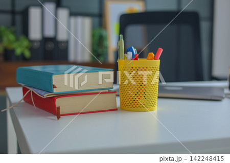 Modern Student Workspace with Stack of Books on White Table. 142248415