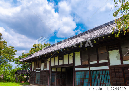 青空と古民家　瓦屋根と緑に囲まれた日本の夏の風景　コピースペースのある背景素材 142249649