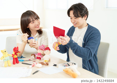 ぬいぐるみ作りを一緒に楽しむ20代の男女 ぬいぐるみ作りを一緒に楽しむ20代の男女 142249884