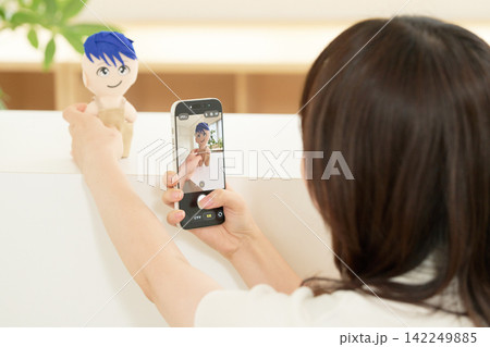 ぬいぐるみにカメラを向ける女性の後ろ姿 142249885