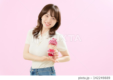 推しぬいを両手で持ち微笑む若い女性 推しぬいを両手で持ち微笑む若い女性 142249889