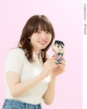 笑顔で推しのぬいぐるみを見せる若い女性 142249913
