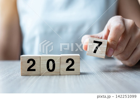 hand flipping block 2026 to 2027 text on table. Resolution, strategy, plan, goal, motivation, reboot, business and New Year holiday concepts hand flipping block 2026 to 2027 text on table. Resolution, strategy, plan, goal, motivation, reboot, business and New Year holiday concepts 142251099