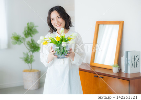 リビングで花瓶を持つる若い女性　　　　 142251521