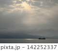 雲間からの光に包まれる静かな海と船 142252337