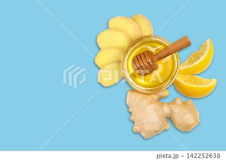Fresh ginger slices are artistically arranged with honey and lemon. Wellness concept Fresh ginger slices are artistically arranged with honey and lemon. Wellness concept 142252638