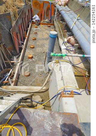 用水路と擁壁で大きな排水管を使用して土木工事をしている様子 用水路と擁壁で大きな排水管を使用して土木工事をしている様子 142254161