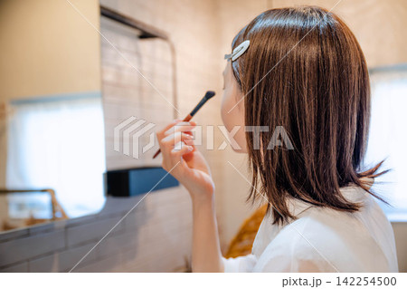 屋内で美容を楽しむ20代女性 142254500