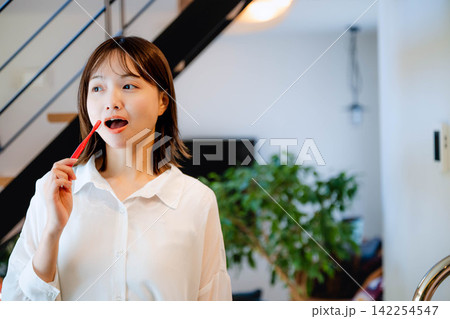 屋内で笑顔を見せる若い女性の日常 屋内で笑顔を見せる若い女性の日常 142254547
