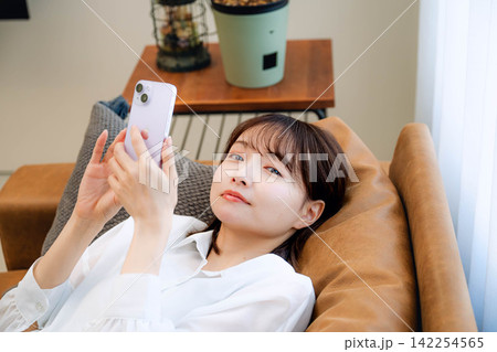 スマートフォンを見る20代女性 スマートフォンを見る20代女性 142254565
