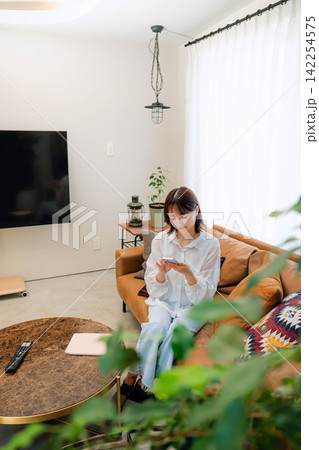 リビングでリラックスする日本人女性 142254575