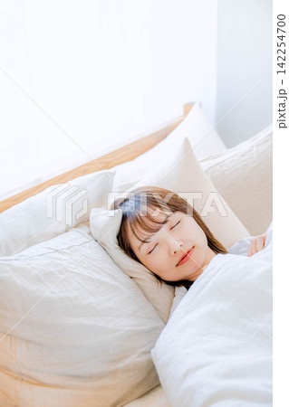 ベッドで眠る20代女性 ベッドで眠る20代女性 142254700
