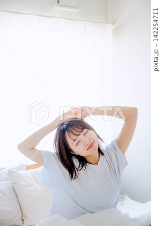 朝ベッドで起きる若い女性 朝ベッドで起きる若い女性 142254711