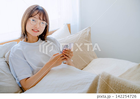 スマホを操作する20代女性のライフスタイル スマホを操作する20代女性のライフスタイル 142254726