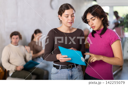 Young female secretary talking with a girl in reception area Young female secretary talking with a girl in reception area 142255079