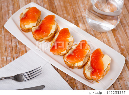 Sandwiches with smoked salmon and butter on white plate 142255385