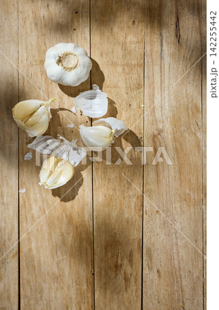 Fresh Garlic on Sunny Old Wooden Kitchen Table, Top View 142255442