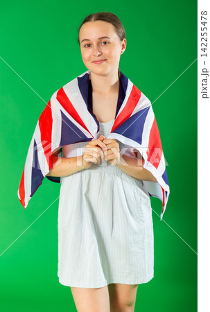 Teenage girl holding UK flag in front of green screen Teenage girl holding UK flag in front of green screen 142255478