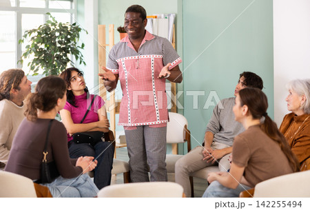 Middle-aged man standing and speaking during circle discussion Middle-aged man standing and speaking during circle discussion 142255494